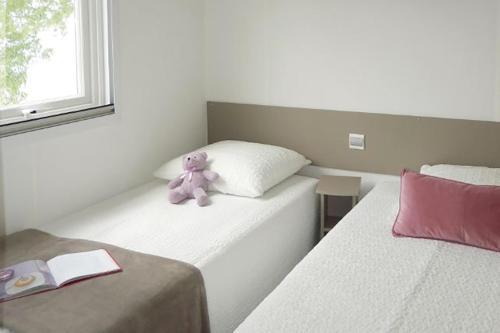 einem lila Teddybär auf zwei Betten in der Unterkunft Les Dunes de Contis in Saint-Julien-en-Born