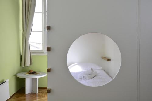 a round mirror in a room with a bed at Hostel Sv. Lovre in Šibenik