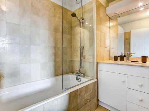 y baño con bañera y ducha acristalada. en Welkeys Apartment - La Fontaine en París