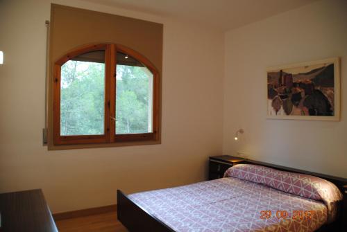 a bedroom with a bed and a window at La Vinya de Mas Pujol in Suria