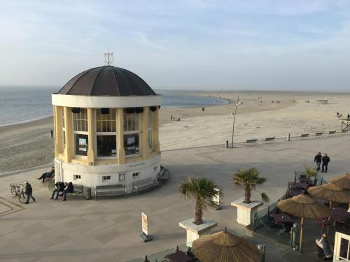 ein Gebäude am Strand neben einem Strand in der Unterkunft FEWO Mövennest in Borkum