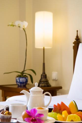 a table with a tea pot and a plate of fruit at The Royal Surakarta Heritage - Handwritten Collection in Solo