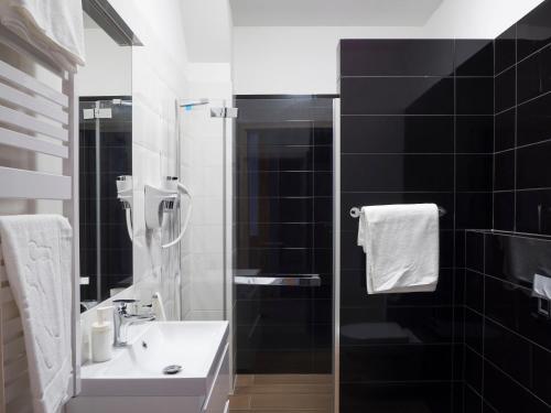 a bathroom with a sink and a shower at Aparthotel CENTRUM Gliwicka 18 in Bytom