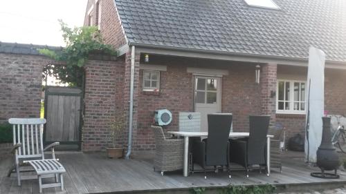 a patio with a table and chairs on a deck at 't Hagerhuys in Maaseik