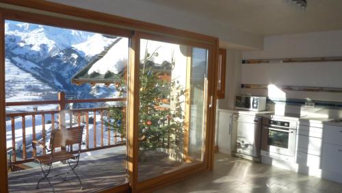 une cuisine avec un arbre de Noël sur un balcon dans l'établissement Chalet D' Edmond, à Bourg-Saint-Maurice