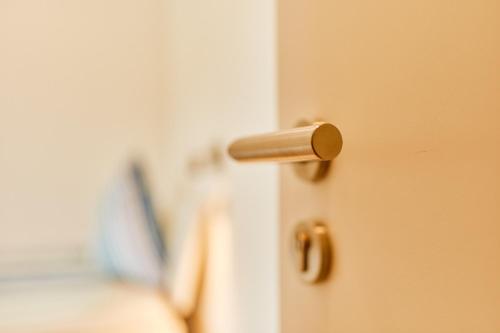 a door knob on a door with a room in the background at Wein-Quartier Leo Pazen in Zeltingen-Rachtig