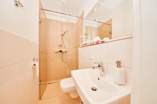 a bathroom with a sink and a toilet and a shower at Wein-Quartier Leo Pazen in Zeltingen-Rachtig