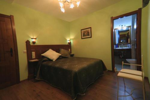 a bedroom with a bed and a large window at Hotel Rural El Caseron de Linarejos in Linarejos
