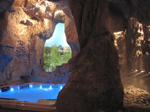 a rock cave with a hot tub inside of it at Posada Los Templarios in Ucero