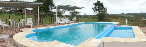 una piscina con sedie e tavolo di Cabañas del Peñasco ad Alpa Corral