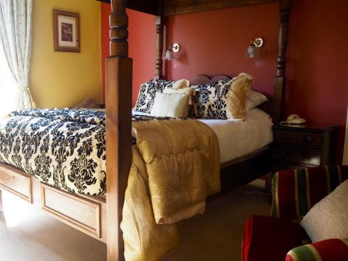 a bedroom with a four poster bed with pillows at Wrangham House in Filey