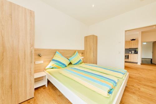 a bedroom with a bed with a wooden headboard at Wein-Quartier Leo Pazen in Zeltingen-Rachtig