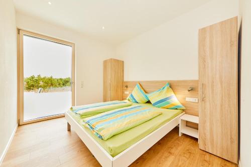 a bedroom with a bed and a large window at Wein-Quartier Leo Pazen in Zeltingen-Rachtig