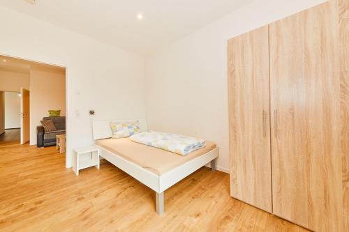 a small bedroom with a bed and a wooden cabinet at Wein-Quartier Leo Pazen in Zeltingen-Rachtig