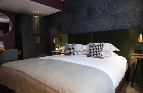 a bedroom with a large bed with pillows on it at Hotel Du Vin Stratford in Stratford-upon-Avon