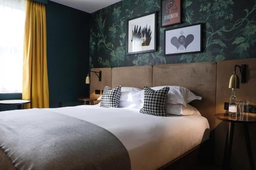 a bedroom with a large bed with green wallpaper at Hotel Du Vin Stratford in Stratford-upon-Avon