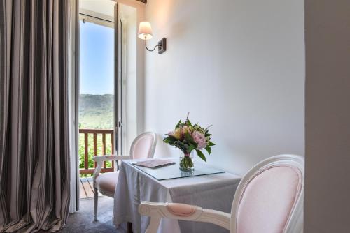 a dining room with a table and chairs and a window at Les Jardins de Bakea in Biriatou