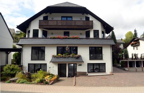 a large white house with flowers in the windows at Hotel Leise Garni in Willingen