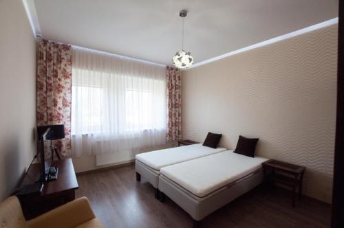 a room with two beds and a window at Prestige apartment in Komárno