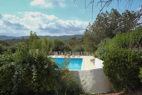 una piscina en medio de un patio con árboles en Mini Villa Santa en Porto Vecchio