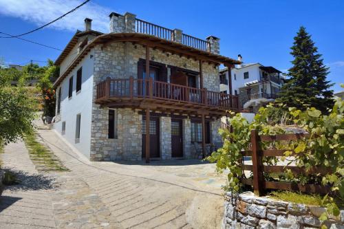 a large stone house with a balcony on top of it at Mple Feggari in Mouresi