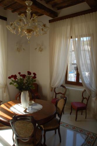 comedor con mesa, sillas y lámpara de araña en Affittacamere Le Fonti, en Arcidosso