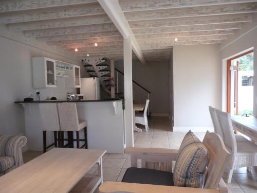 Una cocina y una sala de estar con mesa y sillas. en 75 The Dunes, en Plettenberg Bay