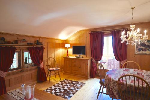 a dining room with a table and a television at Apartments Villa Surlej in Davos