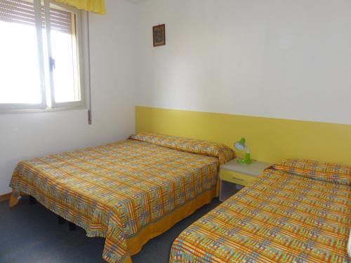 ビビオーネにあるAdriatico - Appartamentiのベッド2台と窓が備わる客室です。