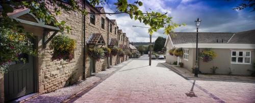 a cobblestone street in a town with buildings at Black Horse Beamish in Stanley