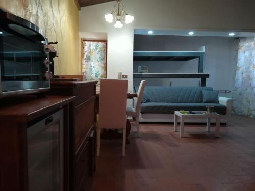 cocina y sala de estar con sofá y mesa en SUITE-TTI, en Valentano