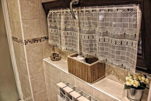 a bathroom with a shower curtain and a basket at Residenza Il Rustico Lago Maggiore in Gravellona Toce