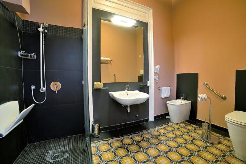 a bathroom with a sink and a shower and a toilet at Spaccanapoli Comfort Suites in Naples