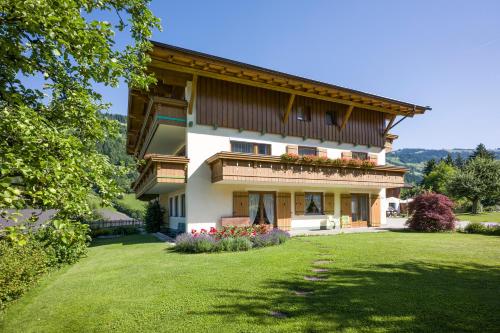 una casa grande con césped delante en Pension Sonnblick, en Westendorf