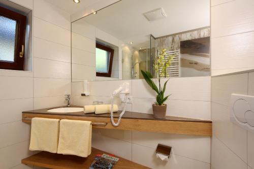 y baño con lavabo y espejo. en Hotel Sportpension Carinthia, en Sölden