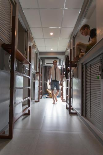 a man walking down a hallway in a hospital at P168 Hostel Samui in Chaweng