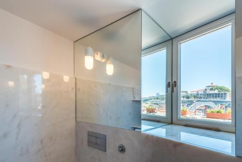 a bathroom with a shower with a large window at Casa Dona Olga River View in Porto