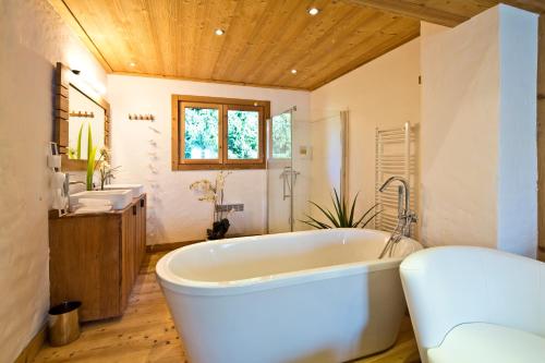 La grande salle de bains est pourvue d'une baignoire et de deux lavabos. dans l'établissement Chalet la Brunette, à Megève