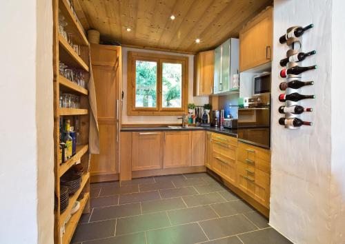 une grande cuisine avec des placards en bois et une fenêtre dans l'établissement Chalet la Brunette, à Megève