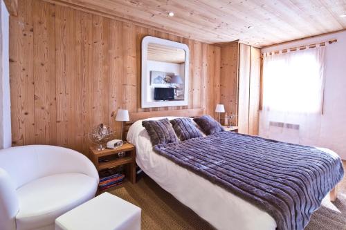 ムジェーヴにあるChalet la Brunetteのベッドルーム1室(ベッド1台、椅子、窓付)
