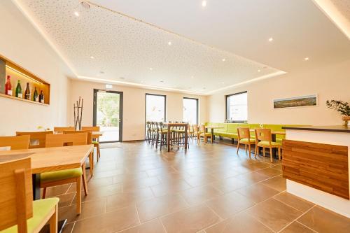 a dining room with tables and chairs and windows at Wein-Quartier Leo Pazen in Zeltingen-Rachtig