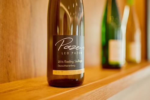 a bottle of wine sitting on a wooden shelf at Wein-Quartier Leo Pazen in Zeltingen-Rachtig