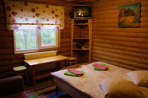 Dormitorio con cama, escritorio y TV en "LiAn" Family Hotel & Restaurant, en Volosyanka