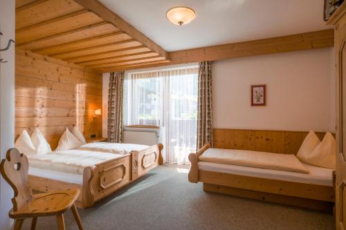 - une chambre avec 2 lits et une fenêtre dans l'établissement Haus Carolin, à Westendorf