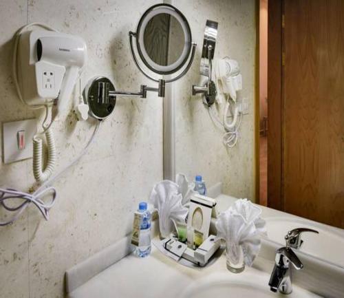 a bathroom sink with a mirror and a hair dryer at Golden dune Hotel Services-Al Fayhaa in Riyadh
