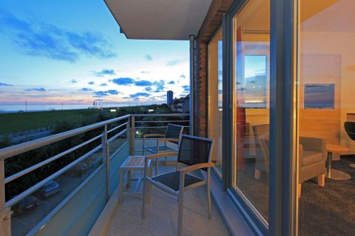 a balcony of a house with chairs and a table at Hotel Schelf GmbH & Co. KG in Büsum