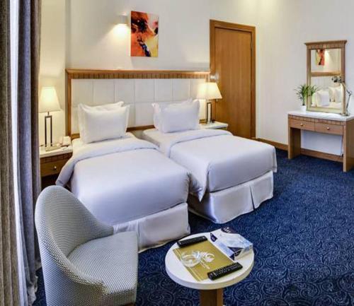 a hotel room with two beds and a table at Golden dune Hotel Services-Al Fayhaa in Riyadh