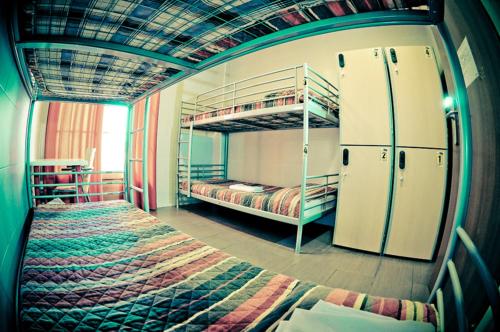 a room with two bunk beds and a refrigerator at Be Zaragoza Hostel in Zaragoza