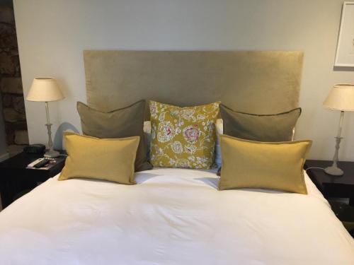 a bed with three pillows on it with two lamps at The Parkwood in Johannesburg