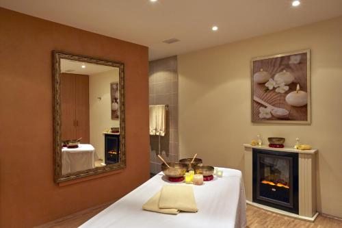 a room with a table with a fireplace and a mirror at H+ Hotel & SPA Friedrichroda in Friedrichroda